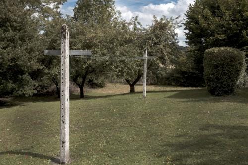 Deux poteaux en forme de croix relié par un fil de linge tendu dans un paysage verdoyant, Dans la Creuse en France