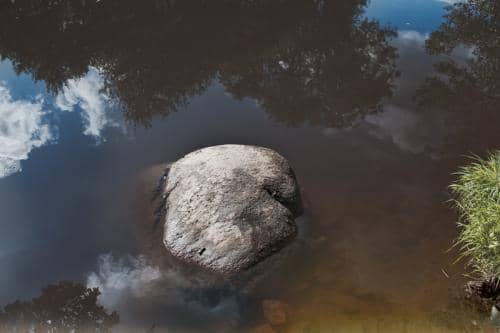 Des pierres dans un ruisseau et un reflet de nature sauvage et d'un ciel contrasté dans la Creuse en France